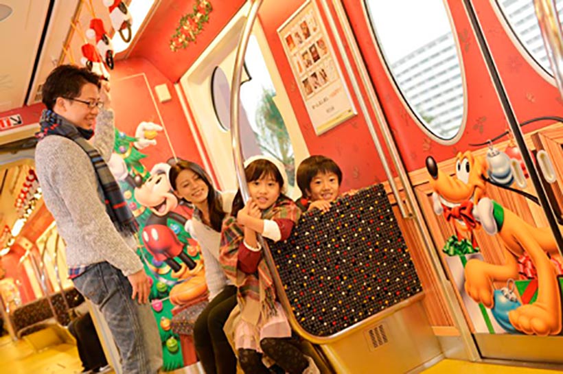 クリスマス仕様のモノレールに乗った家族の画像