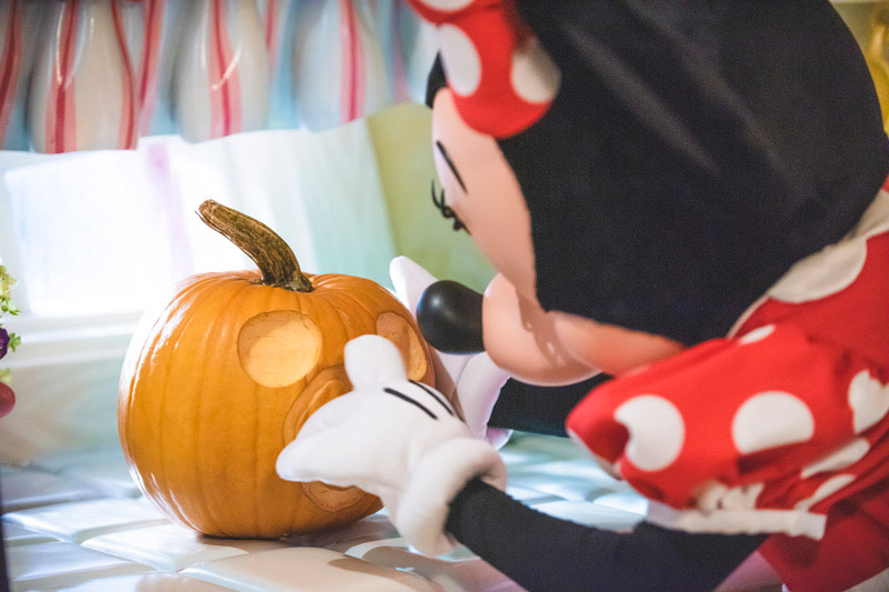 かぼちゃを彫っているミニーの後ろ姿の画像