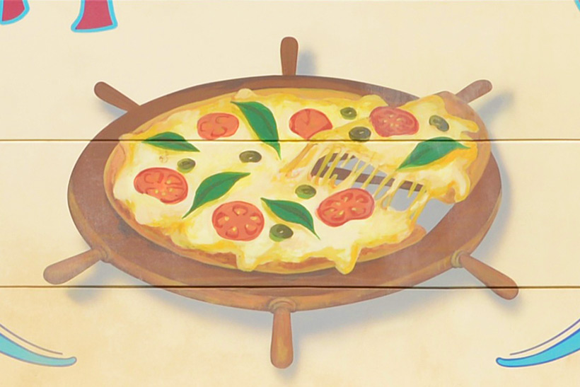 舵輪をお皿にしているピザの画像
